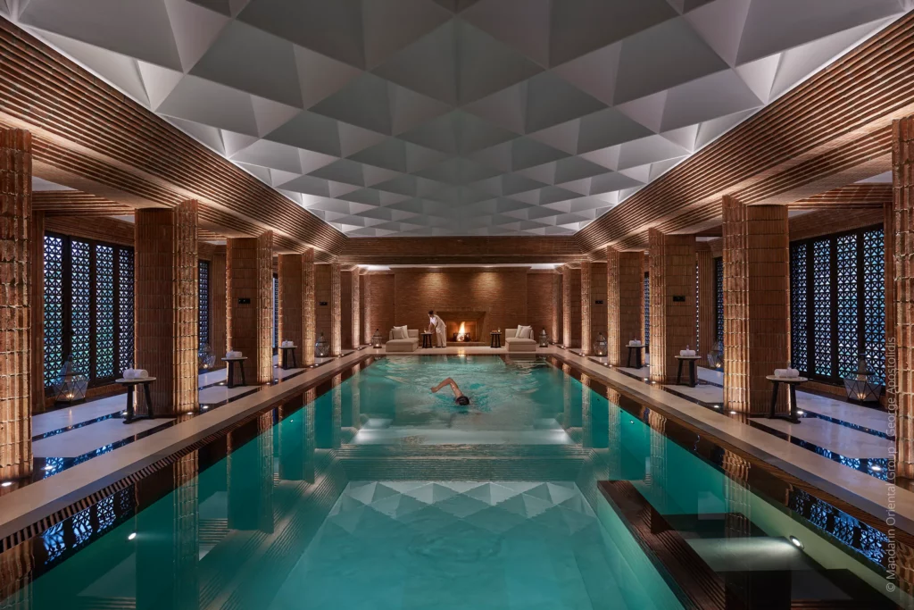 Spa du Mandarin Oriental Marrakech avec piscine interieure illuminee au crepuscule.